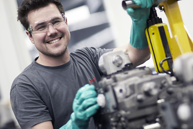 Junger Danfoss Mitarbeiter arbeitet an einer Maschine
