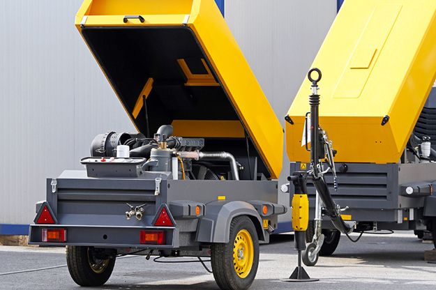 A yellow and grey air compressor out in the field and full of Danfoss products