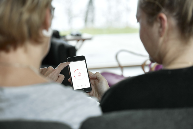 2 Personen schaut Danfoss App