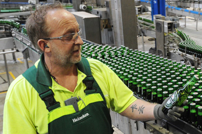 Чоловік перевіряє пляшку HEINEKEN біля лінії розливу