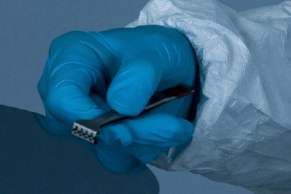 A gloved hand cleaning a unit representing the High-Pressure Pump options for LCD and electronic parts Cleaning by Danfoss