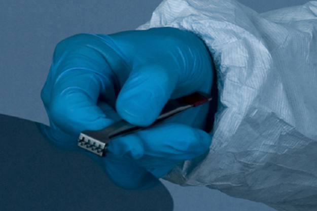A gloved hand cleaning a unit representing the High-Pressure Pump options for LCD and electronic parts Cleaning by Danfoss