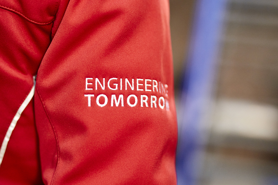 The left sleeve of a red Danfoss jacket with "Engineering Tomorrow" written on the arm