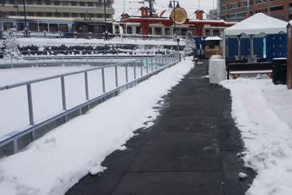 sidewalk cleared of snow next to an ice rink