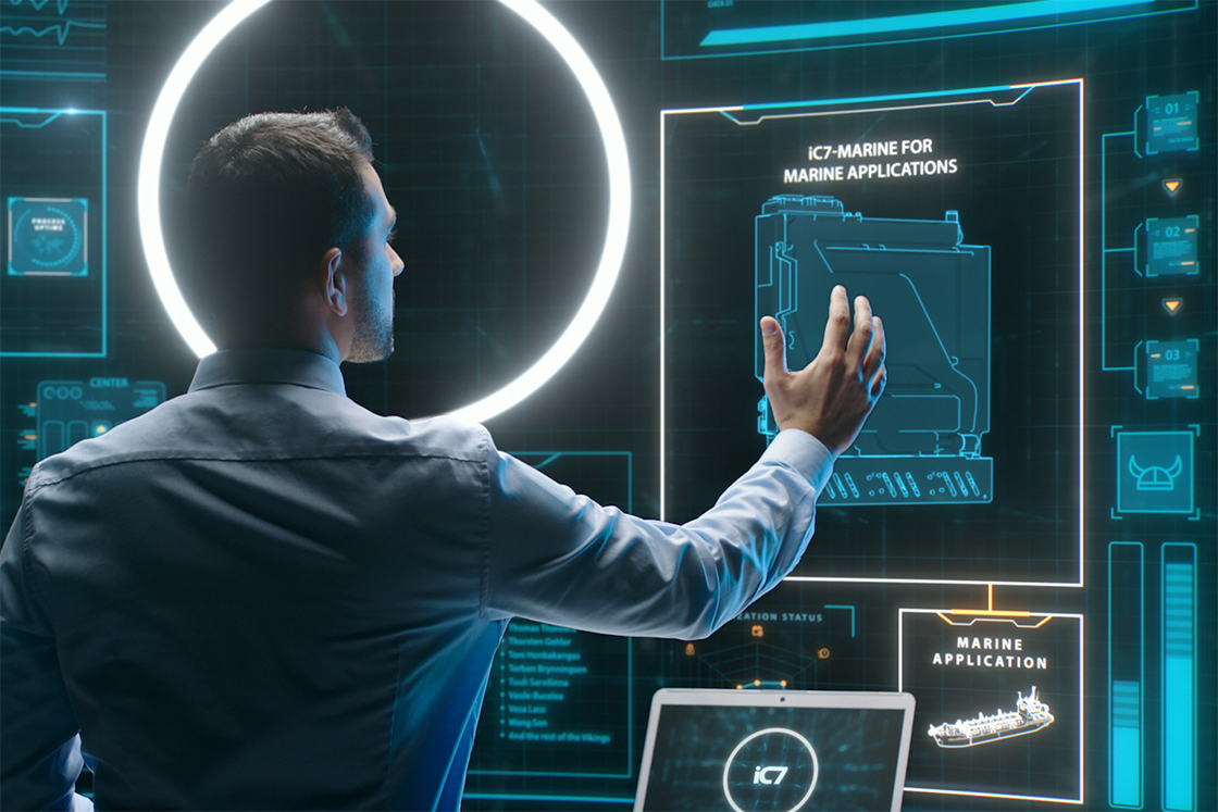 An einem virtuellen Bildschirm mit der Aufschrift „iC7-Marine für Seefahrtanwendungen“ arbeitender Mann