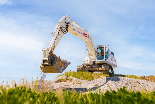 Excavator operating in field