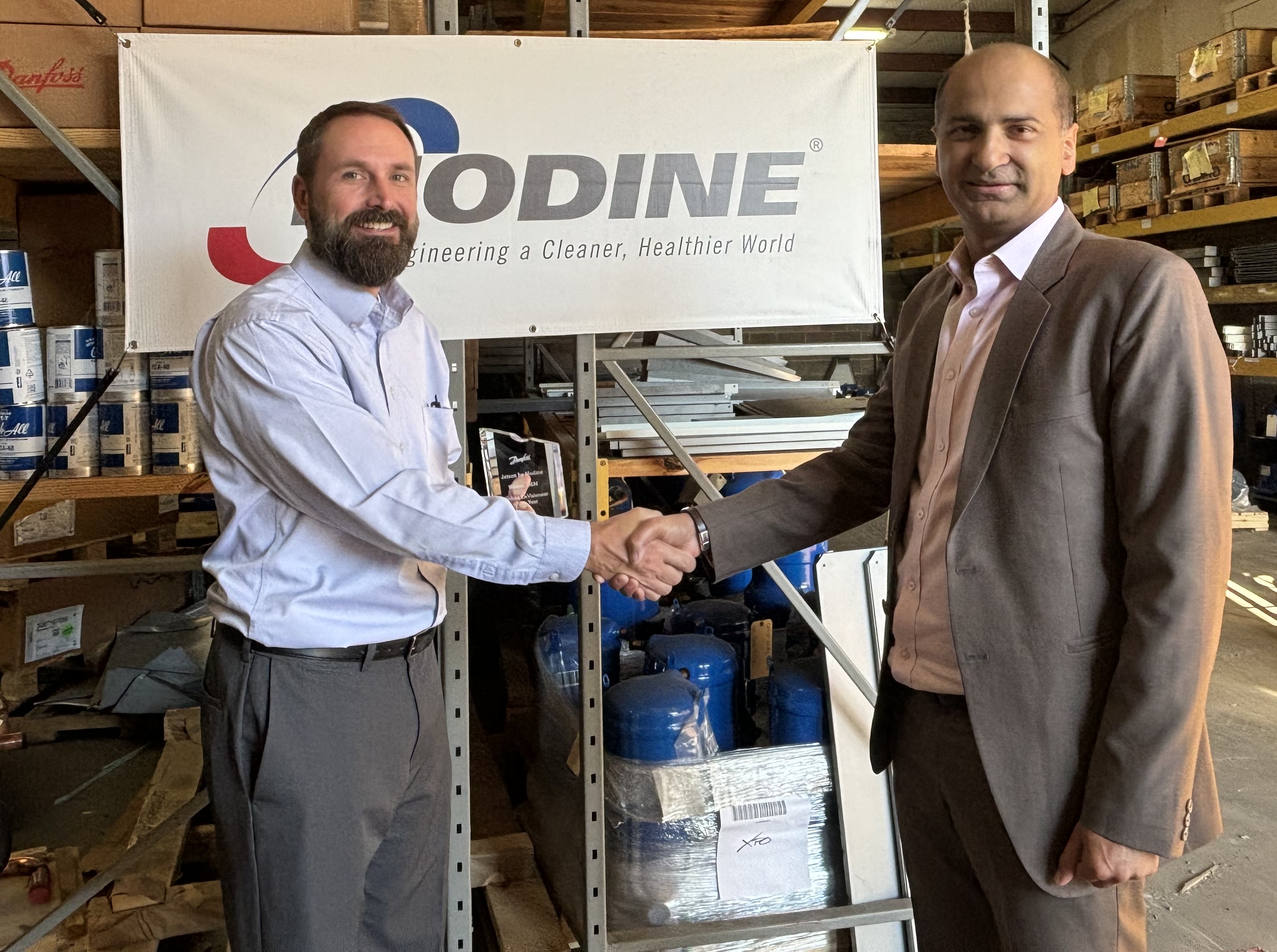 Sam Neale, vice president and general manager of commercial HVAC at Modine (left) is presented with Jetson by Modine’s EnVisioneer of the Year award by Vikas Anand, vice president of sales, Danfoss Climate Solutions, North America.