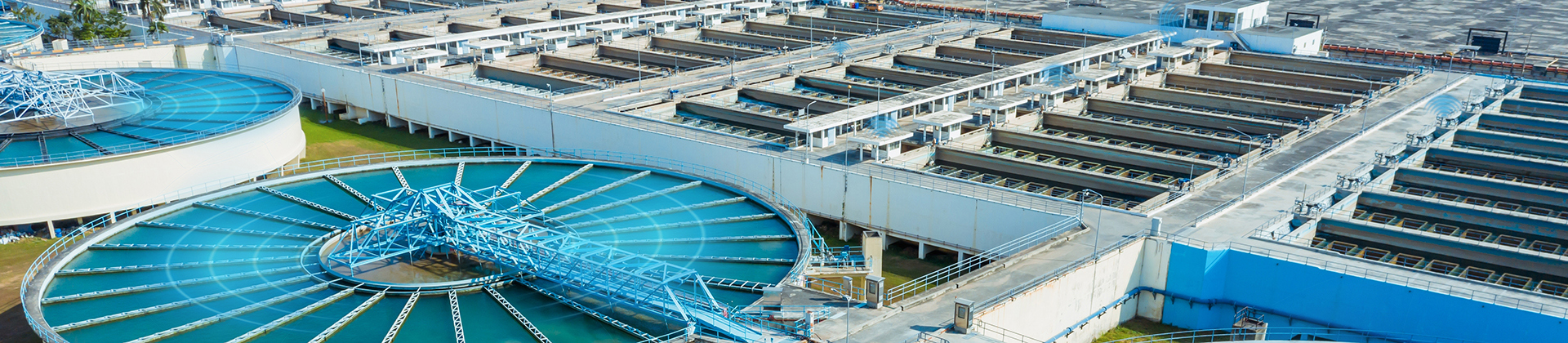 Vista aérea de una planta de tratamiento de aguas residuales, con luces azules que indican sensores para la monitorización de las condiciones