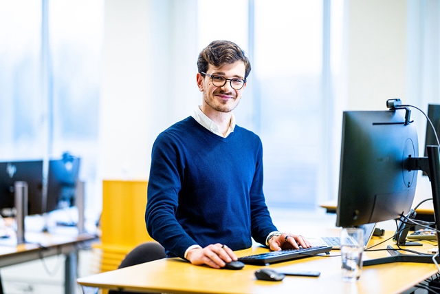 A woman who stands and work on software code