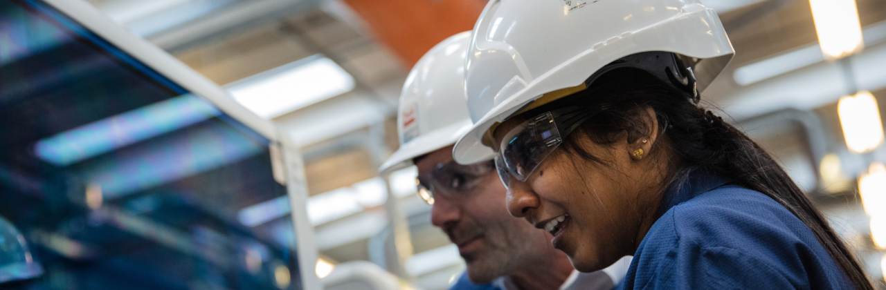 2 personas con cascos visitando una fábrica de Danfoss