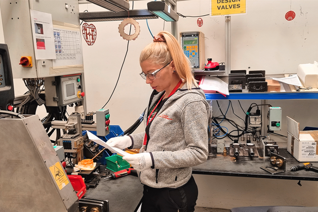 Снимка на Елизабет Русинова на работното място с предпазни очила и ръкавици.