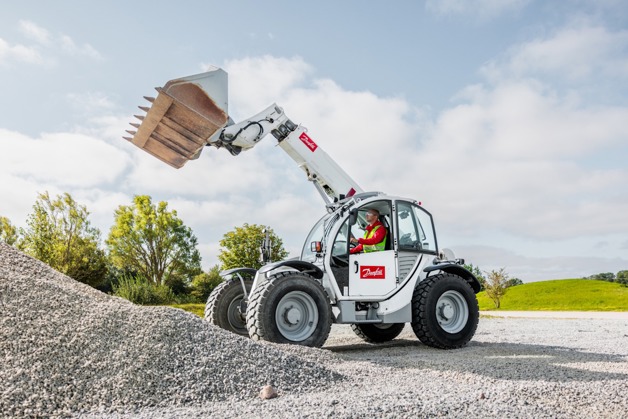 Telehandler driving near pile of rocks
