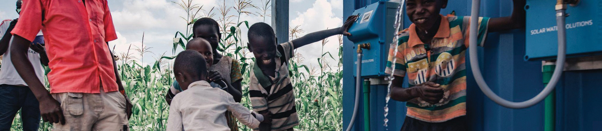 Kids drinking from the water station built by Solar Water Solutions and Danfoss