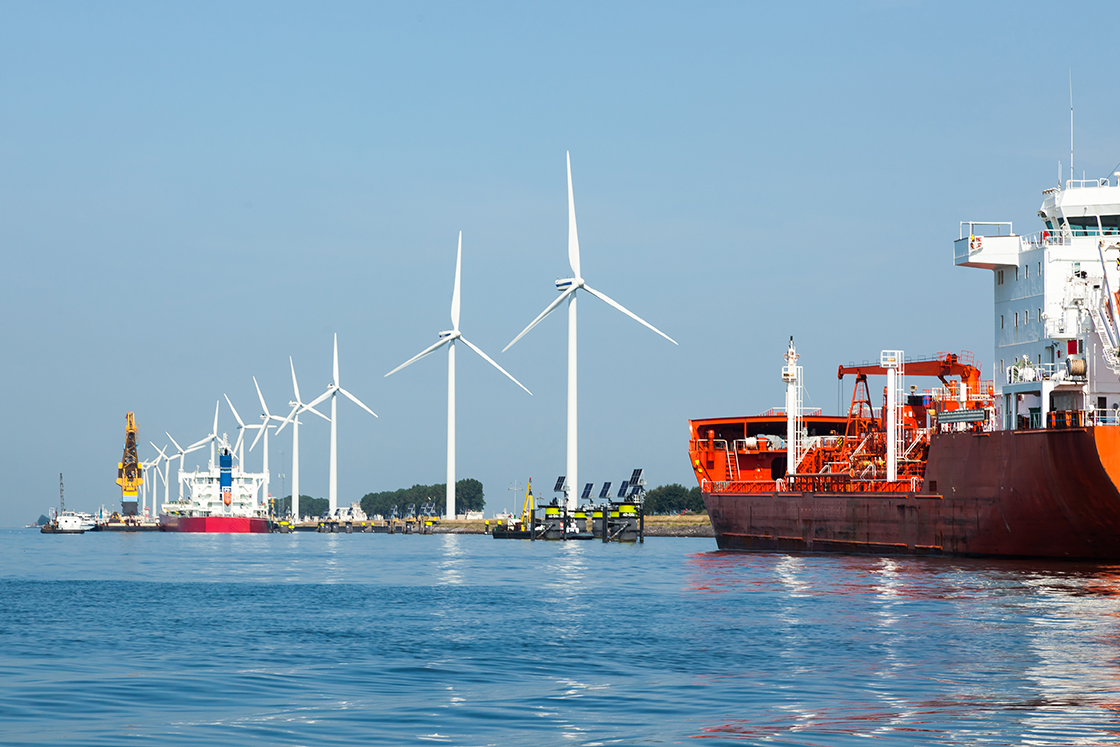 A row of wind turbines and various ships