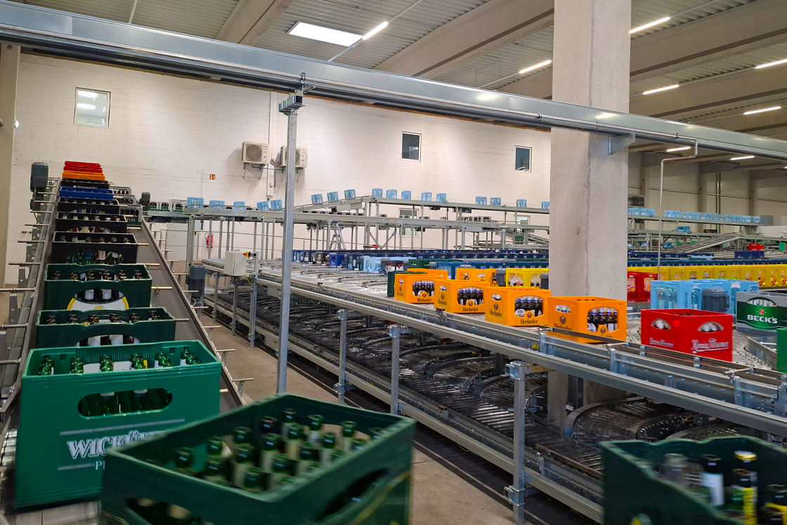 Die Getränkekisten laufen über einen Rollenförderer nach der Sortierung zur Palletieranlage